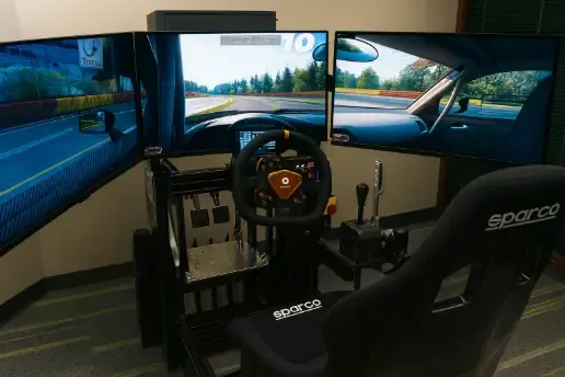 The full racing simulator rig, including three monitors